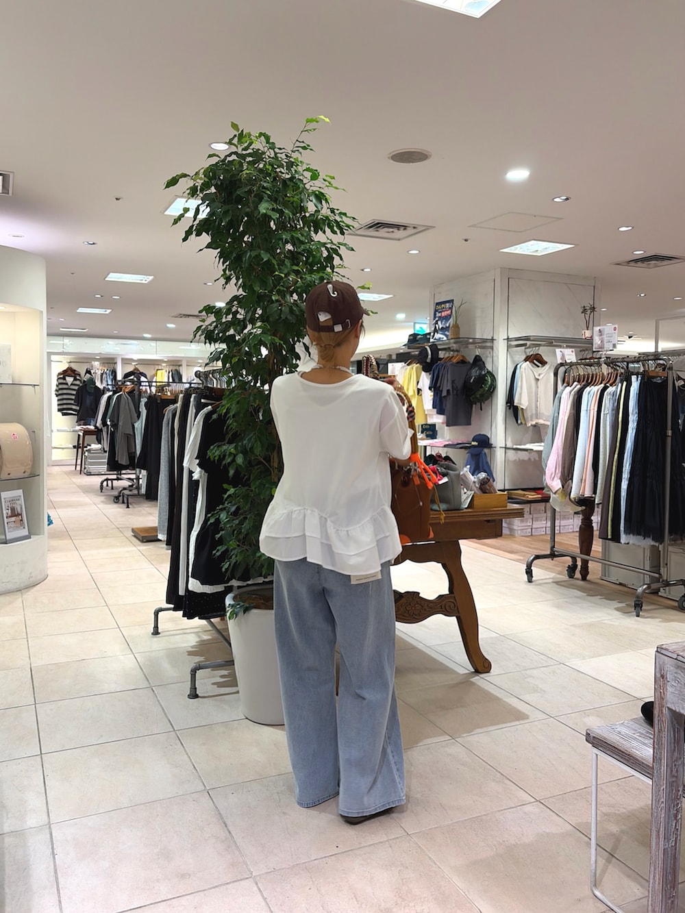 ホワイト系のTシャツ/カットソー、ブルー系のデニムパンツ、イエロー系のショルダーバッグを着用したレディースの夏コーディネートの2枚目の写真