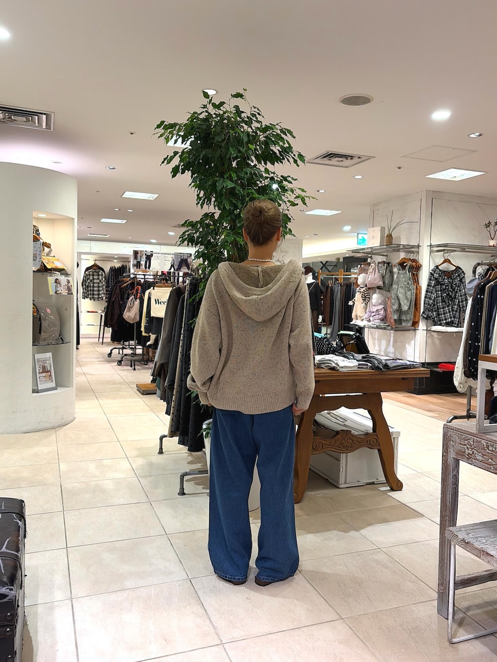 ブラウン系のパンプス、ブルー系のデニムパンツ、ホワイト系のパーカーを着用したレディースの秋コーディネートの2枚目の写真