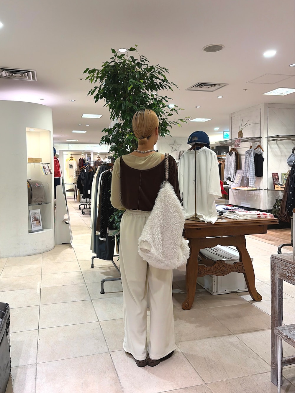 ブラウン系のTシャツ/カットソー、ホワイト系のスラックス、ホワイト系のショルダーバッグを着用したレディースの秋コーディネートの2枚目の写真