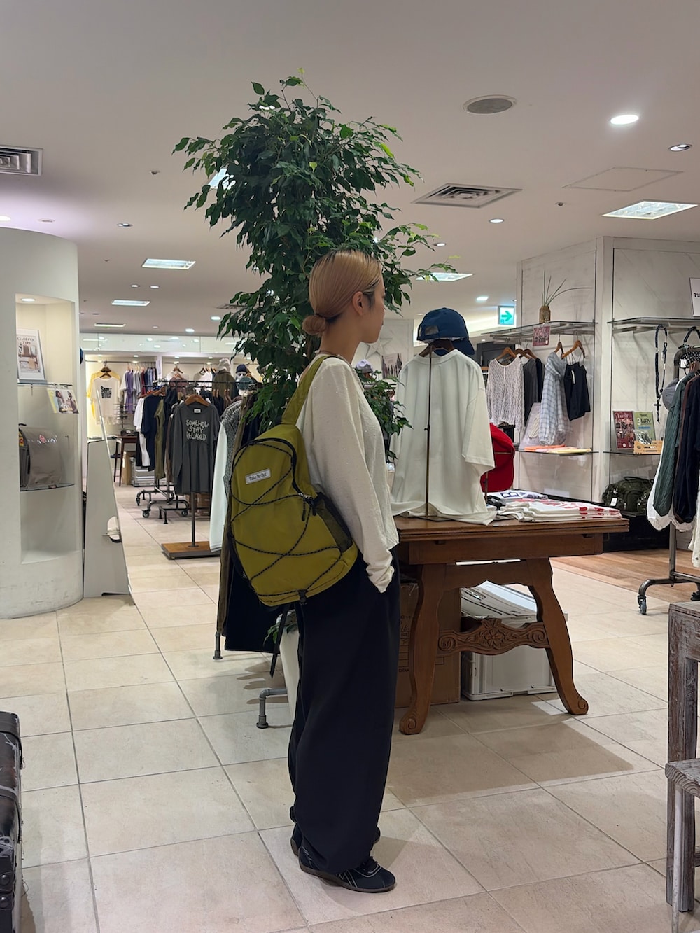 ホワイト系のTシャツ/カットソー、グリーン系のバックパック/リュック、ブラック系のその他パンツを着用したレディースの秋コーディネートの3枚目の写真