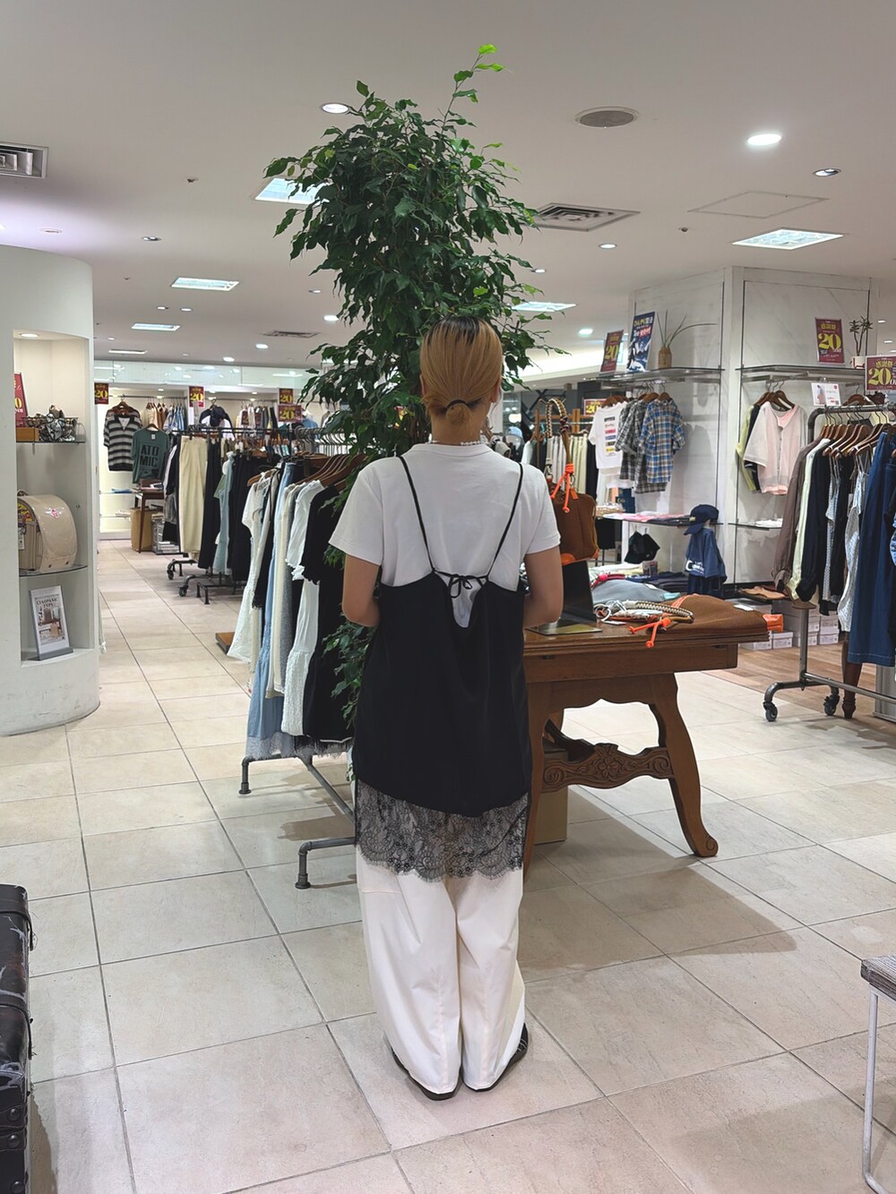 ブラック系のチュニック、ホワイト系のその他パンツを着用したレディースの夏コーディネートの2枚目の写真
