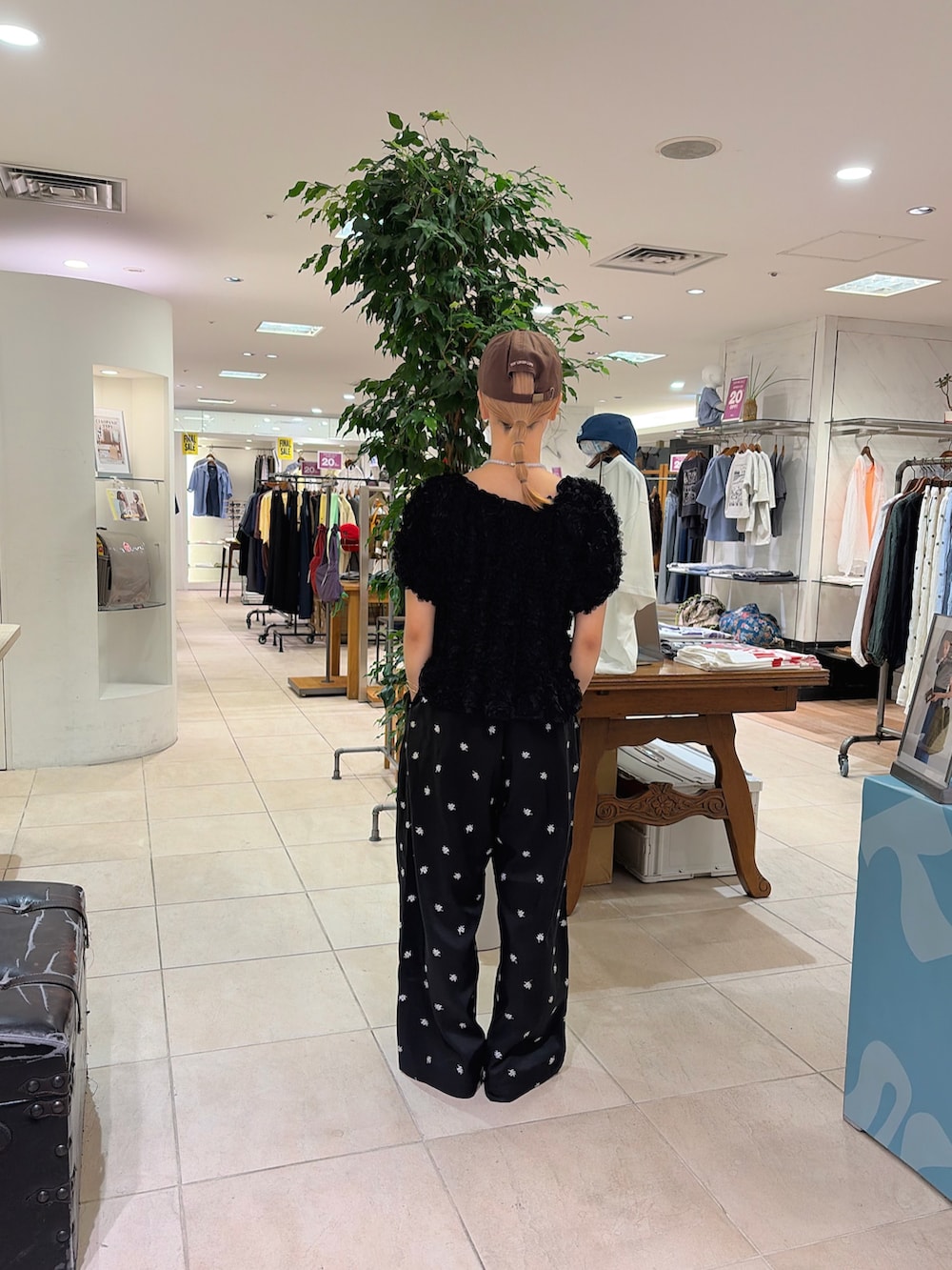ブラック系のシャツ/ブラウス、ブラック系のスラックス、ブラウン系のキャップを着用したレディースの夏コーディネートの3枚目の写真