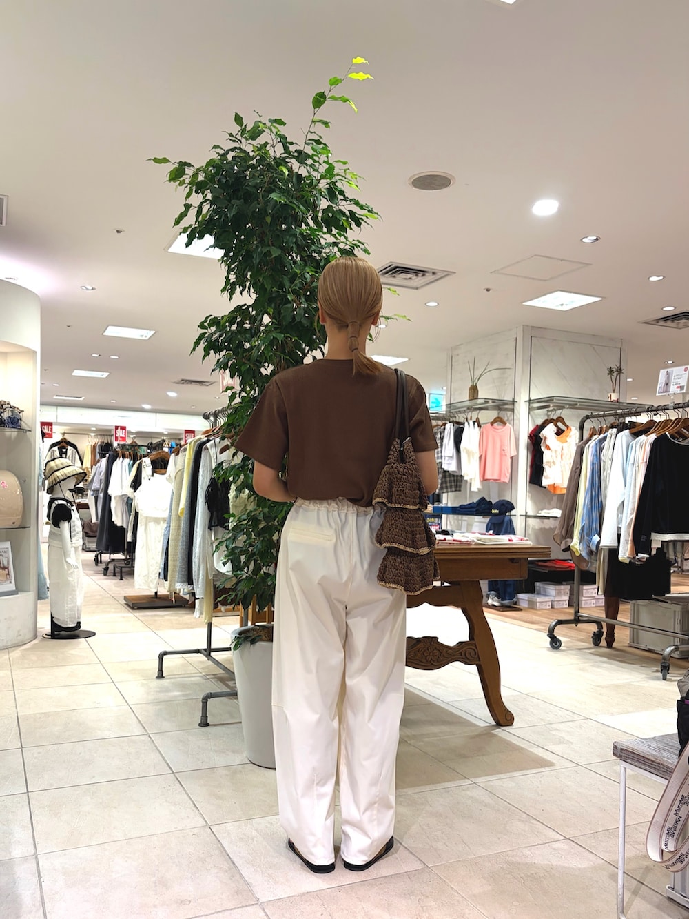 ブラウン系のTシャツ/カットソー、ブラウン系のトートバッグ、ホワイト系のその他パンツを着用したレディースの夏コーディネートの2枚目の写真
