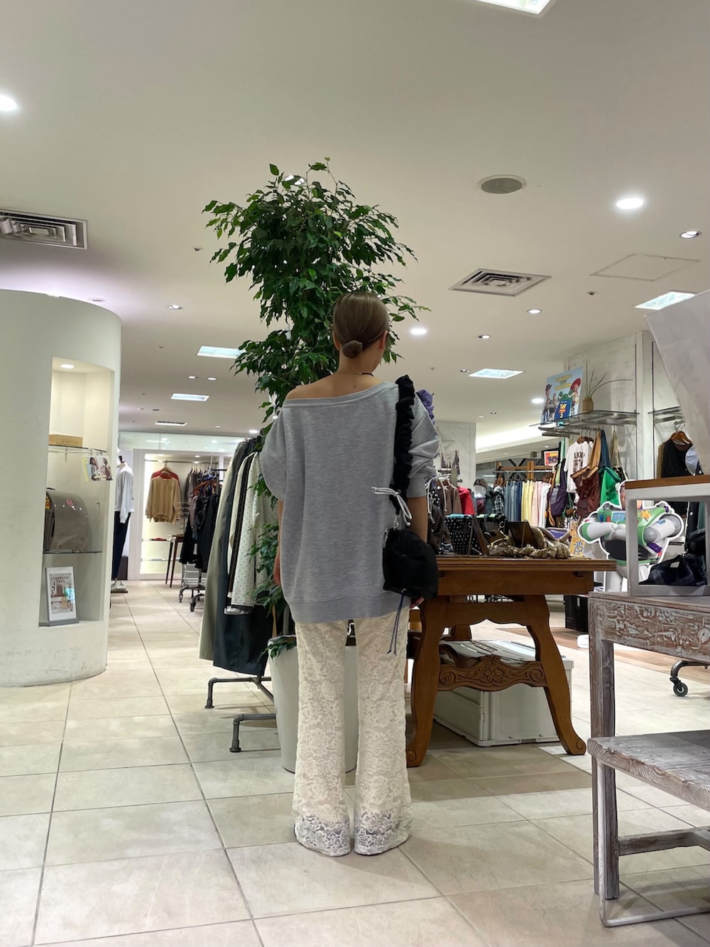 グレー系のスウェット、ブラック系のショルダーバッグ、ホワイト系のその他パンツを着用したレディースの秋コーディネートの3枚目の写真