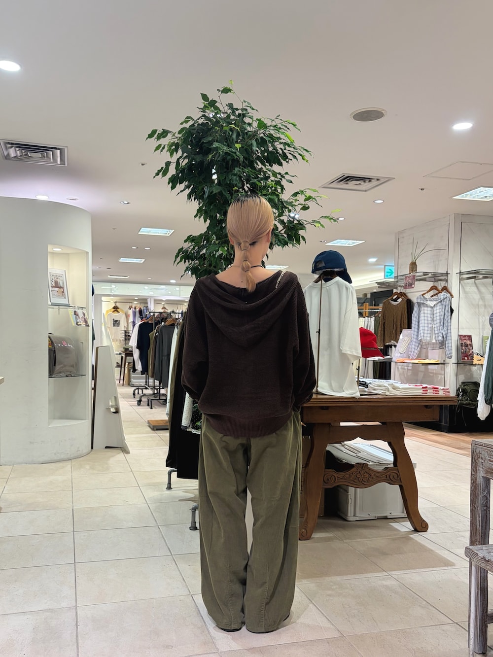 ブラウン系のパーカー、グリーン系のその他パンツ、ブラウン系のスニーカーを着用したレディースの秋コーディネートの3枚目の写真