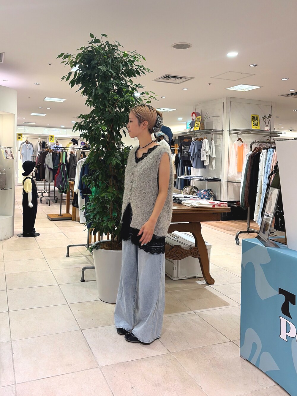 ブラック系のチュニック、グレー系のベスト、ブルー系のデニムパンツを着用したレディースの夏コーディネートの2枚目の写真
