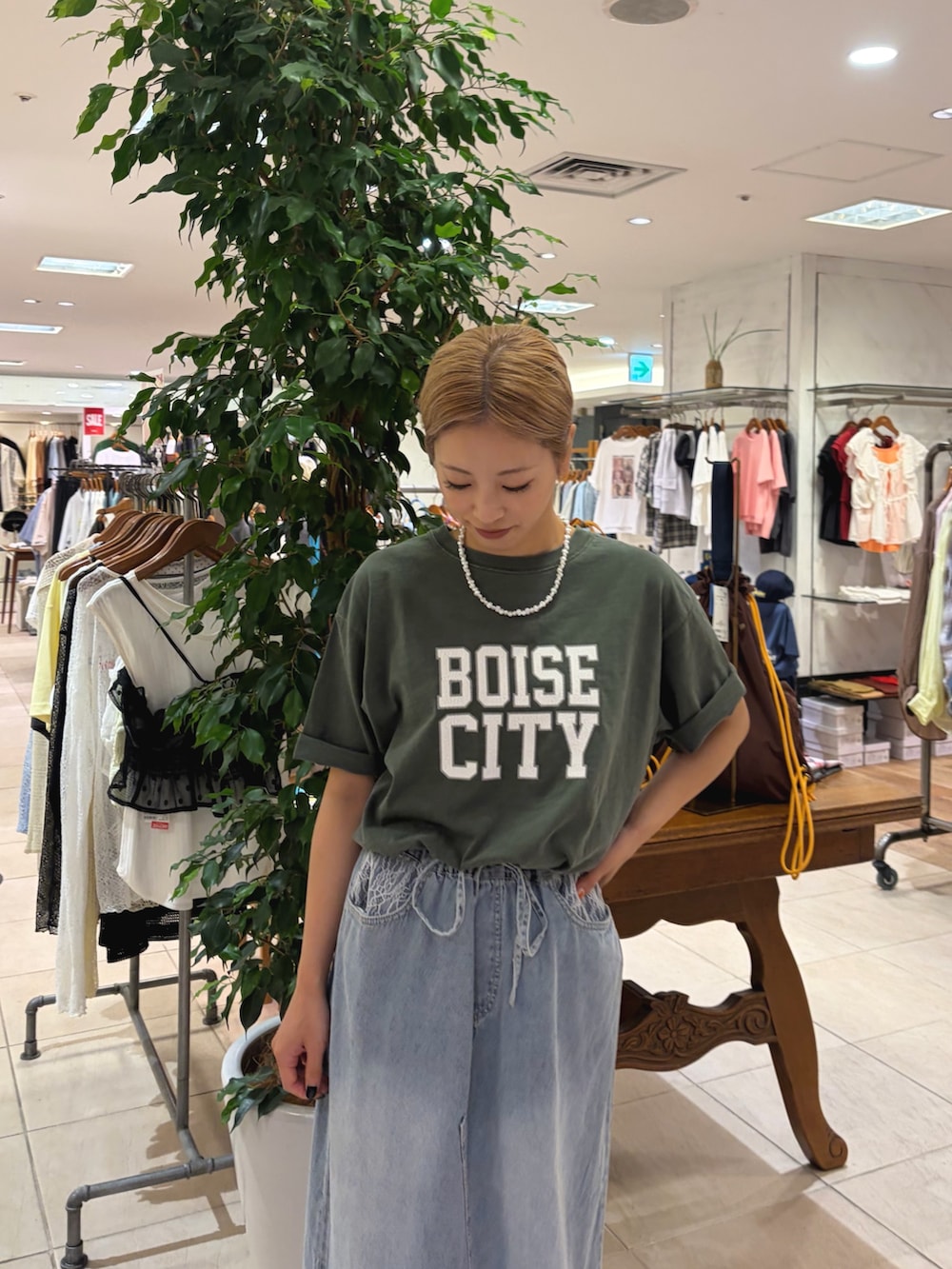 グリーン系のTシャツ/カットソー、ブルー系のスカート、ブラック系のローファーを着用したレディースの夏コーディネートの4枚目の写真