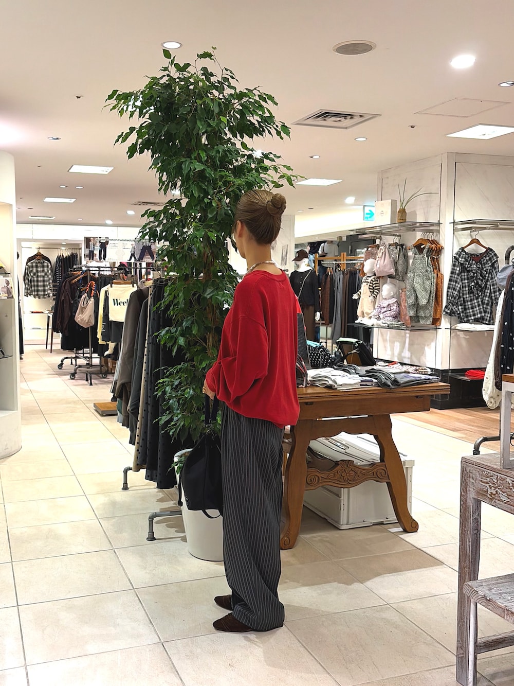 レッド系のニット/セーター、ブラック系のトートバッグ、グレー系のその他パンツを着用したレディースの秋コーディネートの3枚目の写真