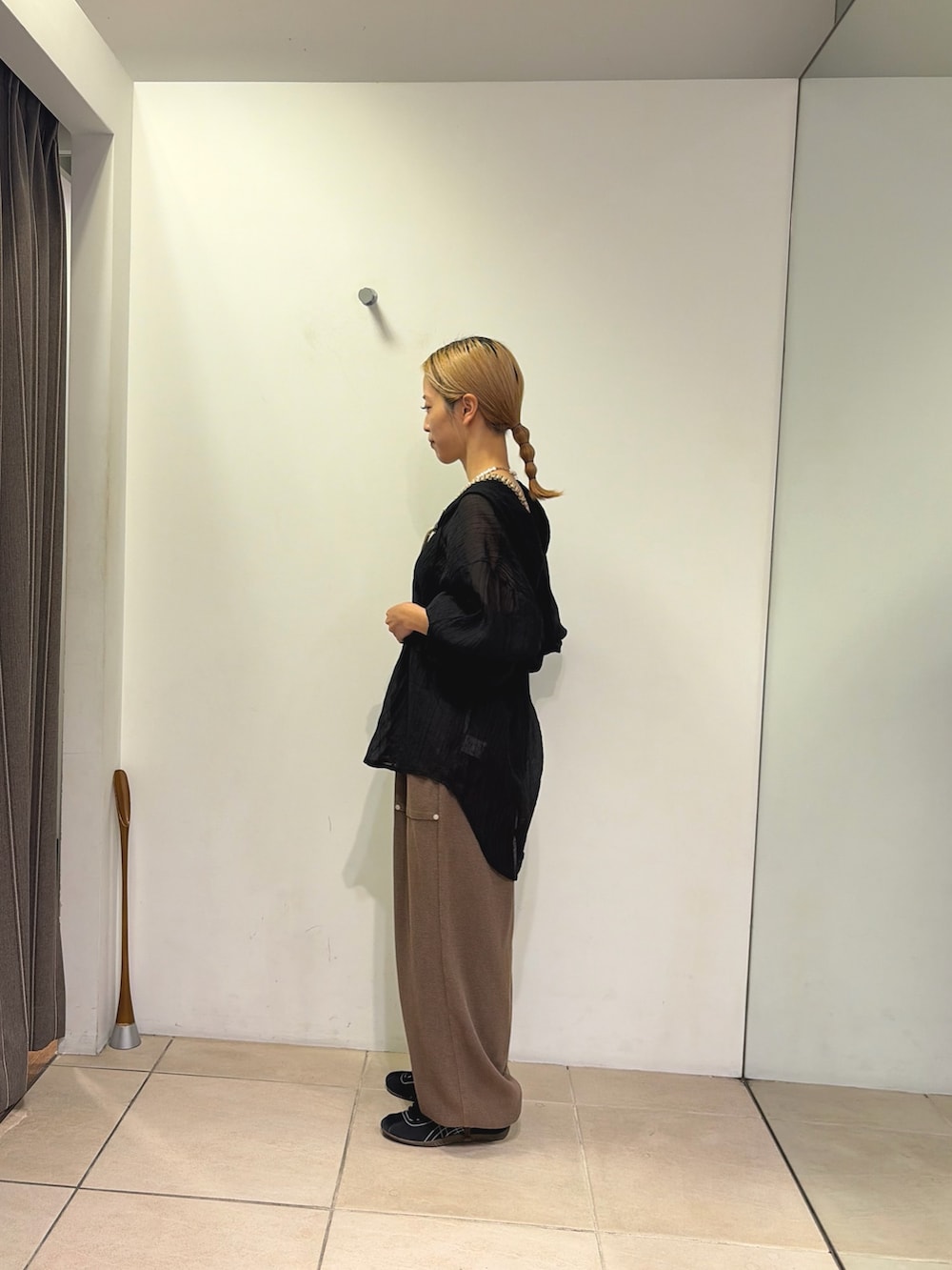 ブラウン系のスウェットパンツ、ブラック系のシャツ/ブラウス、ベージュ系のスマホグッズを着用したレディースの夏コーディネートの2枚目の写真