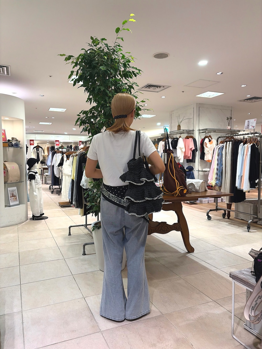 ブラック系のトートバッグ、ブルー系のデニムパンツ、ブラック系のバンダナ/スカーフを着用したレディースの夏コーディネートの2枚目の写真