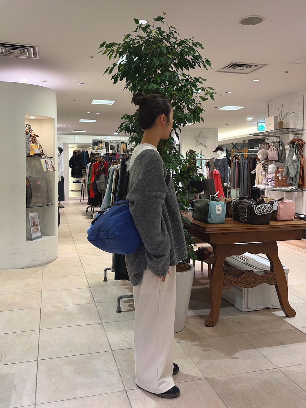 ホワイト系のTシャツ/カットソー、グレー系のニット/セーター、ブルー系のショルダーバッグを着用したレディースの秋コーディネートの2枚目の写真