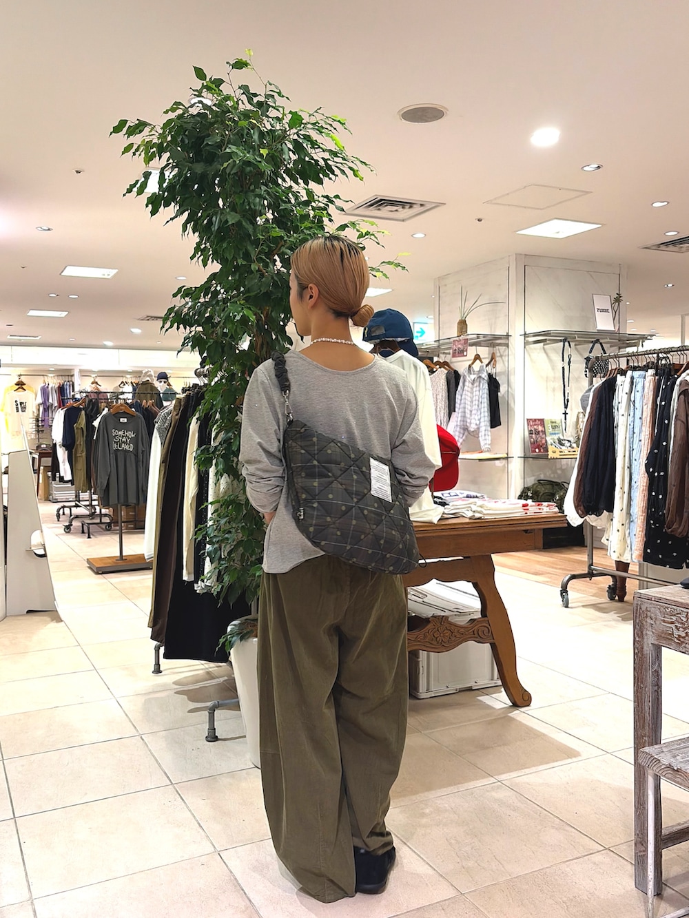 ブラック系のスニーカー、グリーン系のその他パンツ、グレー系のTシャツ/カットソーを着用したレディースの秋コーディネートの3枚目の写真