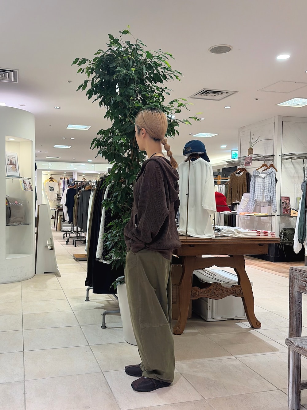 ブラウン系のパーカー、グリーン系のその他パンツ、ブラウン系のスニーカーを着用したレディースの秋コーディネートの2枚目の写真