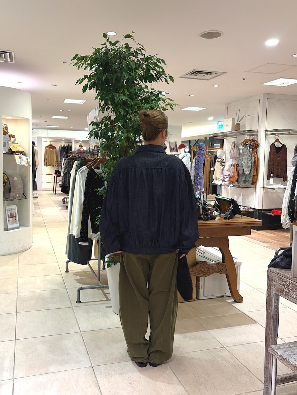 グリーン系のその他パンツ、ブルー系のデニムジャケット、ブラック系のショルダーバッグを着用したレディースの秋コーディネートの3枚目の写真