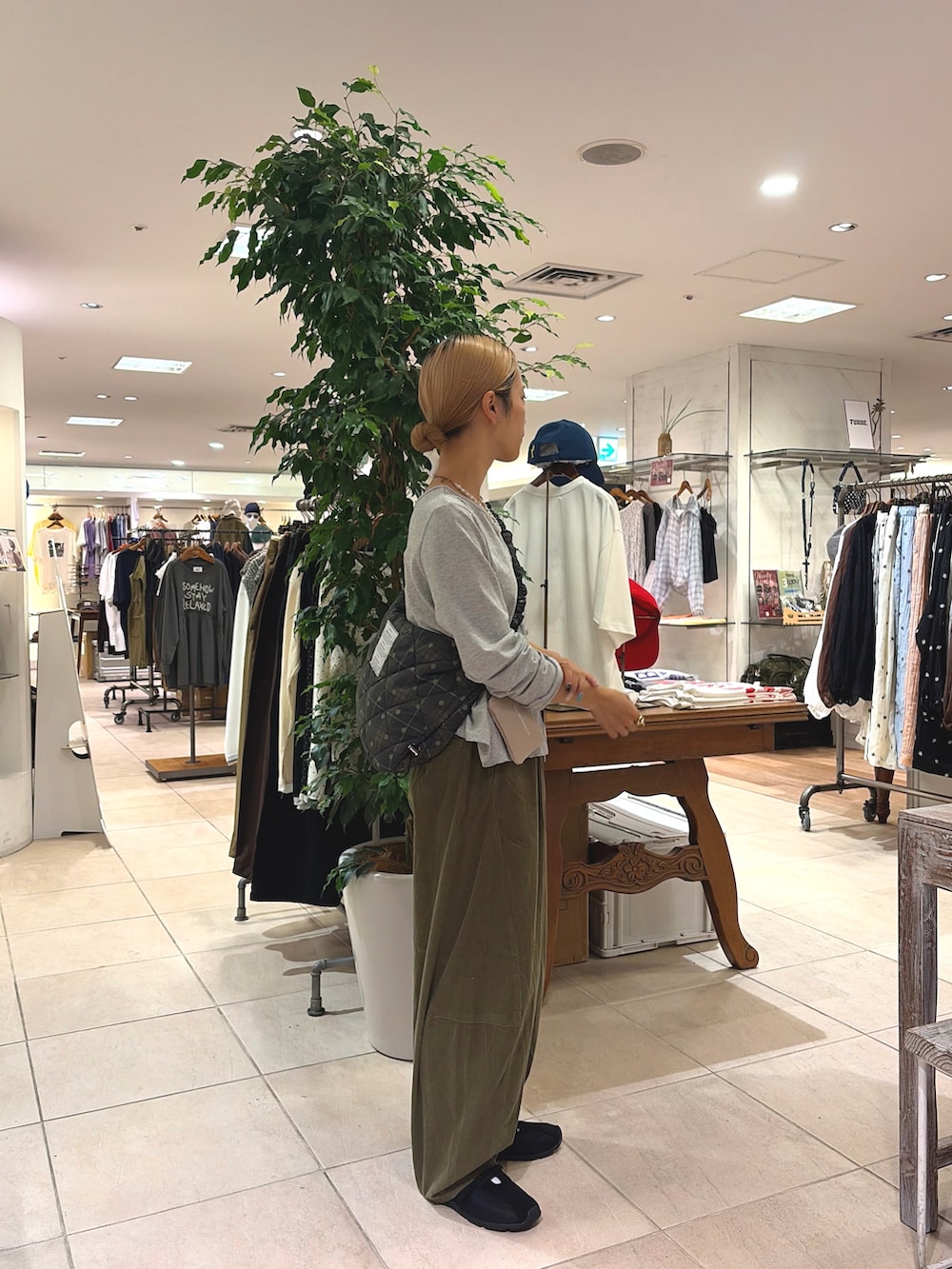 ブラック系のスニーカー、グリーン系のその他パンツ、グレー系のTシャツ/カットソーを着用したレディースの秋コーディネートの2枚目の写真