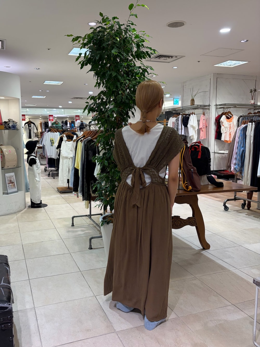 ホワイト系のタンクトップ、グリーン系のワンピース、ブルー系のデニムパンツを着用したレディースの夏コーディネートの2枚目の写真