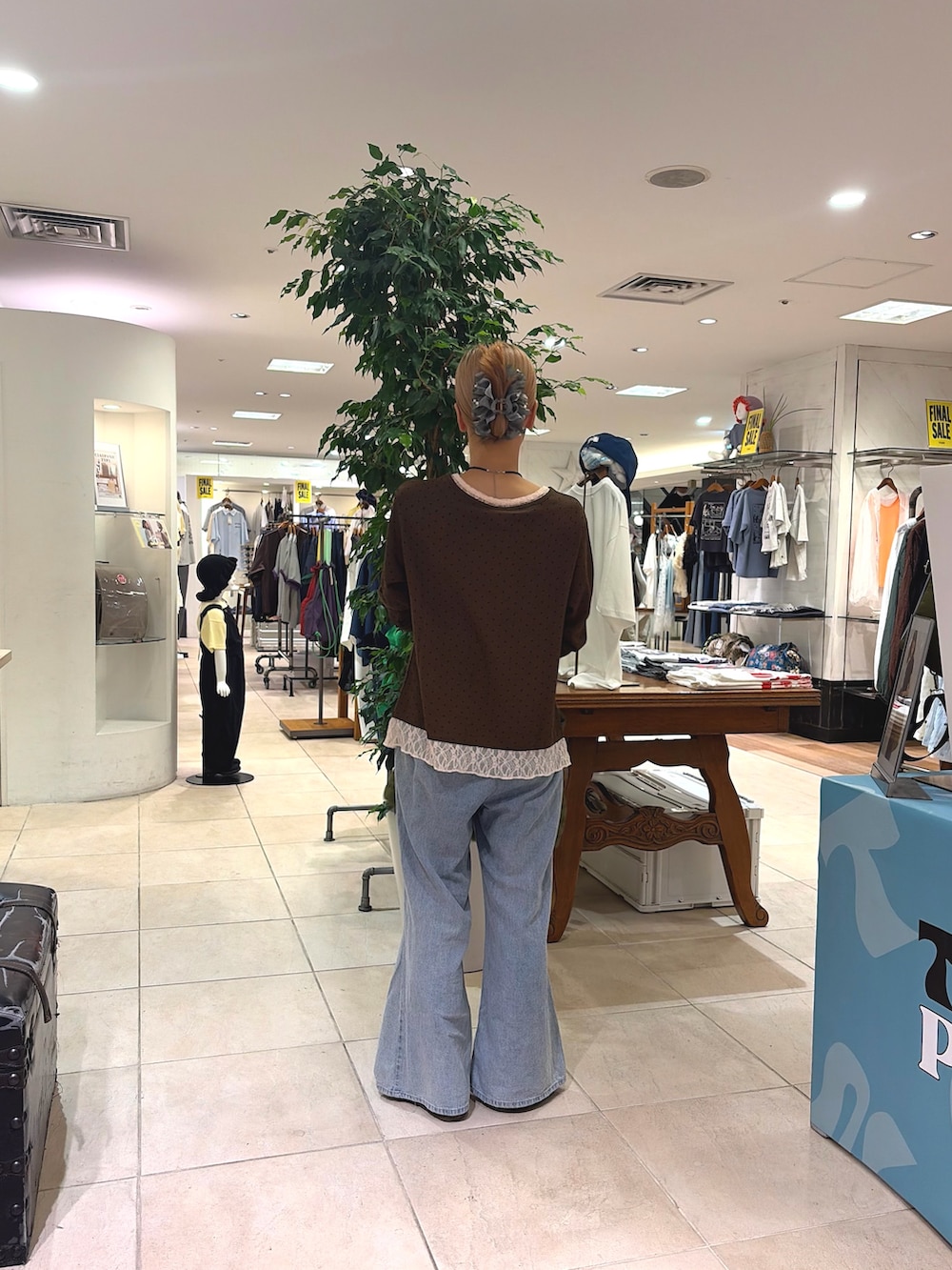 ブラウン系のカーディガン/ボレロ、ブルー系のデニムパンツ、グリーン系のショルダーバッグを着用したレディースの夏コーディネートの2枚目の写真