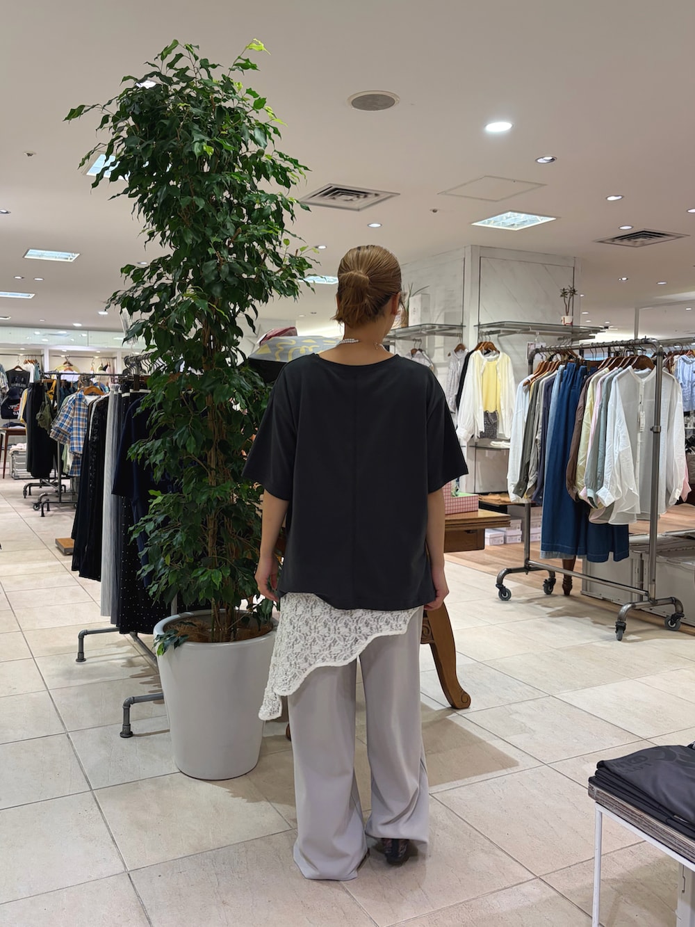 グレー系のTシャツ/カットソー、ホワイト系のタンクトップ、グレー系のスラックスを着用したレディースの春コーディネートの2枚目の写真