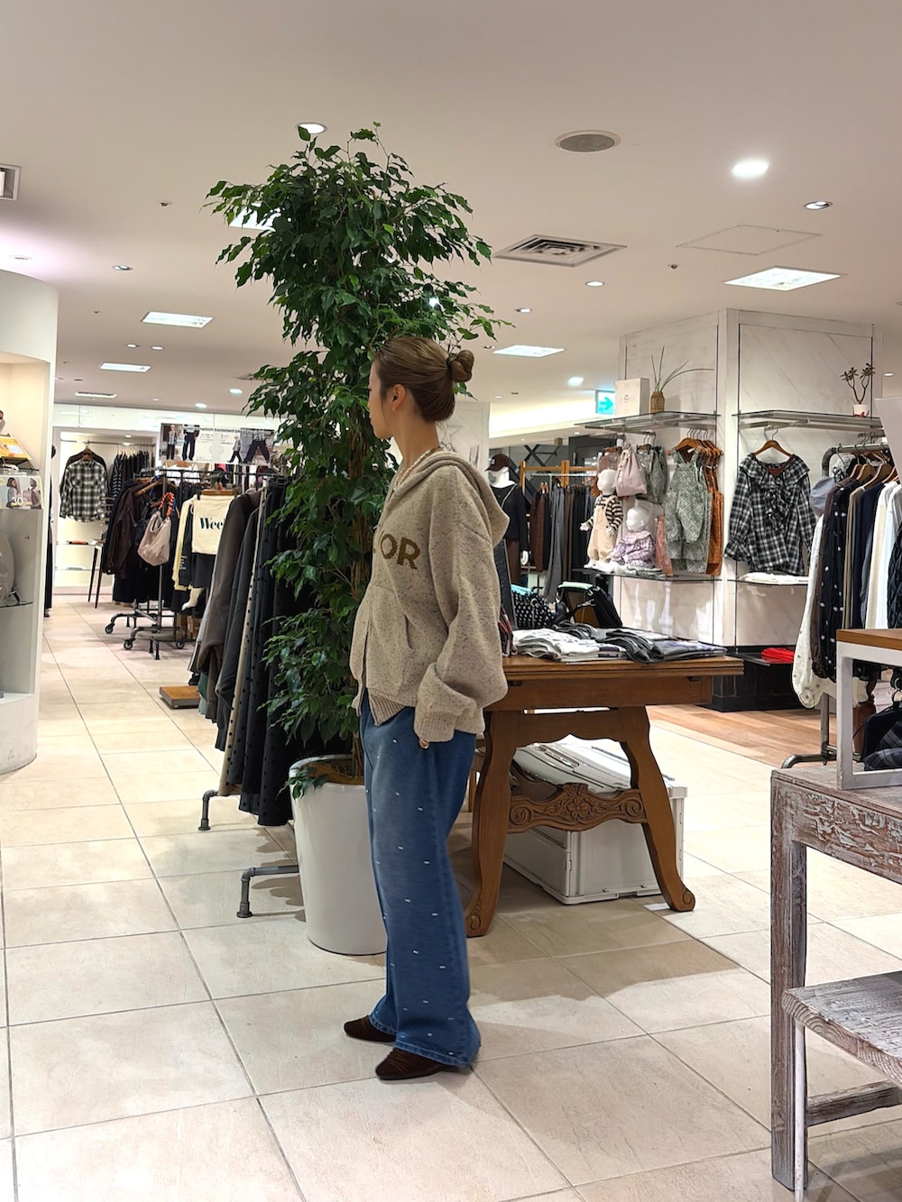 ブラウン系のパンプス、ブルー系のデニムパンツ、ホワイト系のパーカーを着用したレディースの秋コーディネートの3枚目の写真