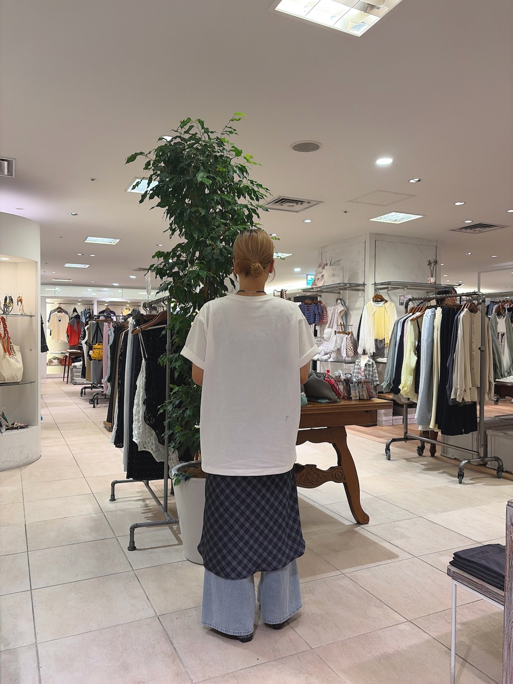 ホワイト系のTシャツ/カットソー、グレー系のスカート、ブルー系のデニムパンツを着用したレディースの春コーディネートの2枚目の写真
