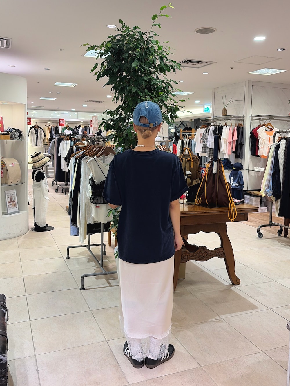 ブルー系のTシャツ/カットソー、ホワイト系のスカート、ブルー系のキャップを着用したレディースの夏コーディネートの3枚目の写真
