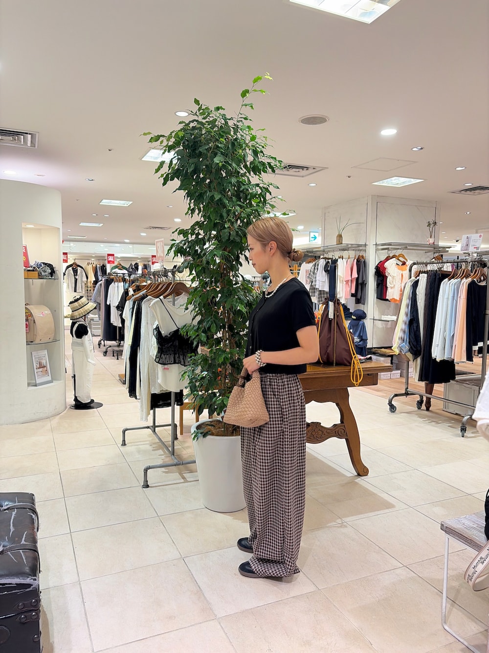 ブラック系のTシャツ/カットソー、ベージュ系のショルダーバッグ、ブラウン系のその他パンツを着用したレディースの夏コーディネートの2枚目の写真