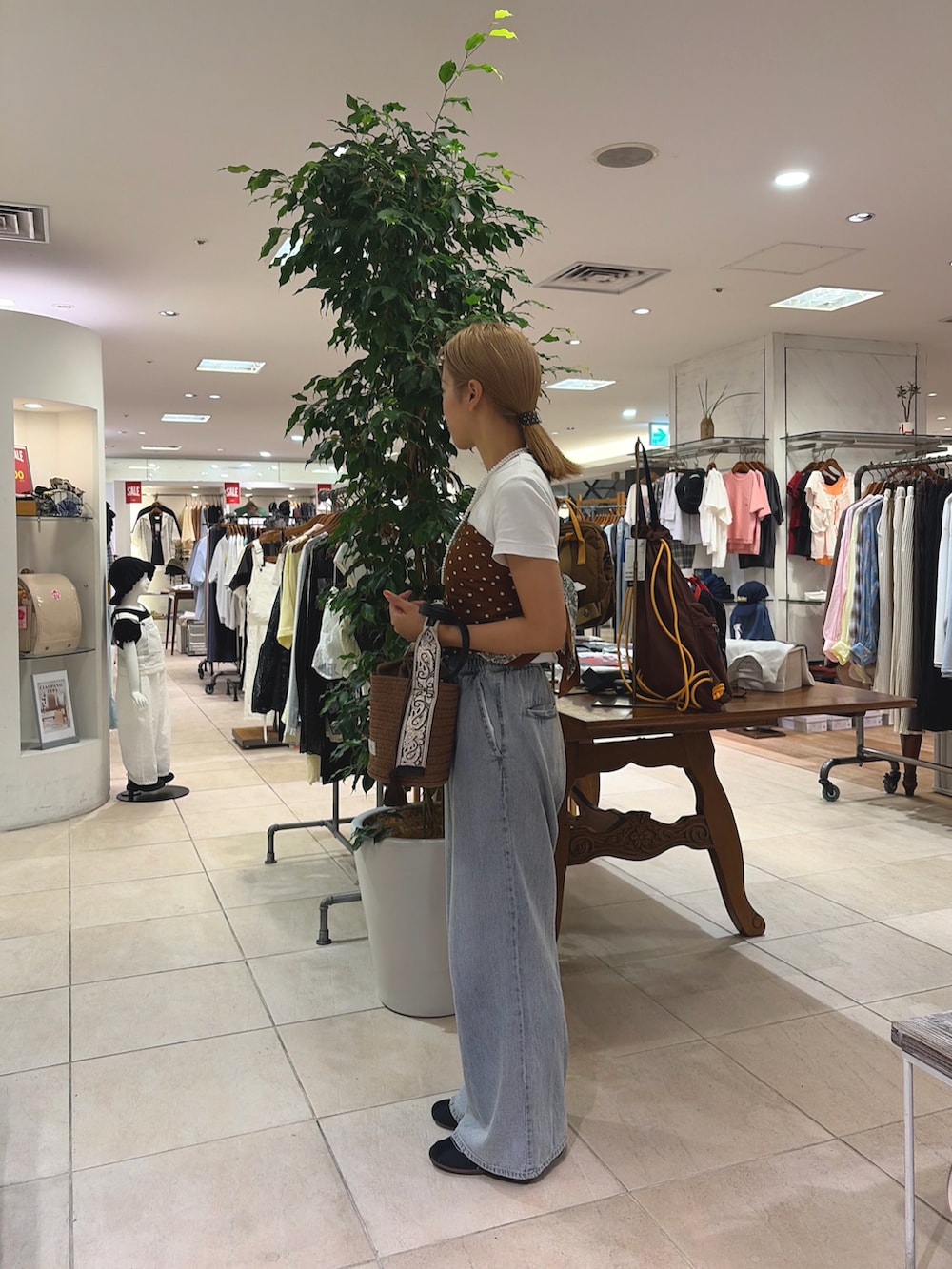 ブラウン系のトートバッグ、ブルー系のデニムパンツ、レッド系のバンダナ/スカーフを着用したレディースの夏コーディネートの2枚目の写真