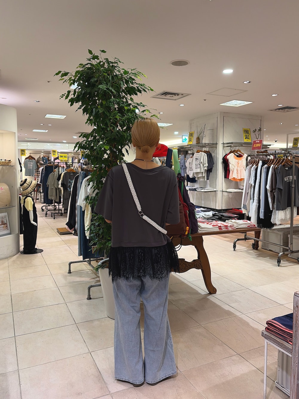 グレー系のTシャツ/カットソー、ブルー系のデニムパンツ、ホワイト系のスマホグッズを着用したレディースの夏コーディネートの2枚目の写真