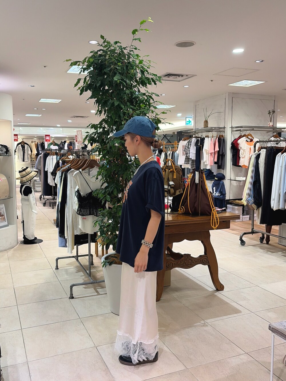 ブルー系のTシャツ/カットソー、ホワイト系のスカート、ブルー系のキャップを着用したレディースの夏コーディネートの2枚目の写真