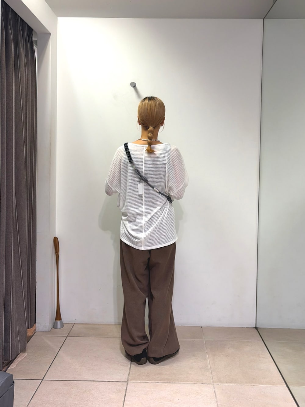 ホワイト系のTシャツ/カットソー、ブラウン系のスウェットパンツ、ブラック系のスマホグッズを着用したレディースの夏コーディネートの2枚目の写真