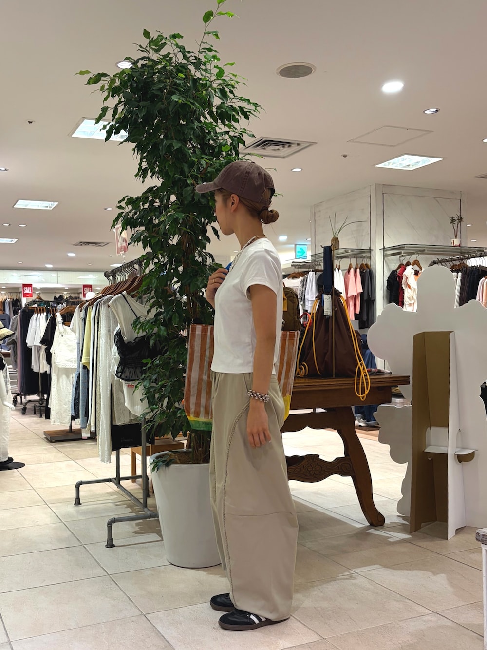 グリーン系のその他パンツ、ブラウン系のキャップ、ブラウン系のネックレスを着用したレディースの夏コーディネートの3枚目の写真