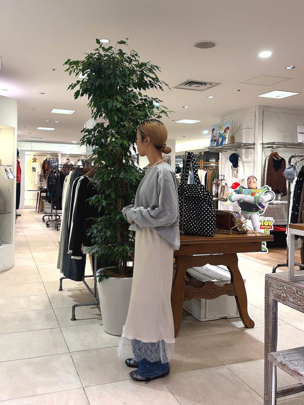 ホワイト系のスカート、ブルー系のデニムパンツ、グレー系のスウェットを着用したレディースの秋コーディネートの3枚目の写真