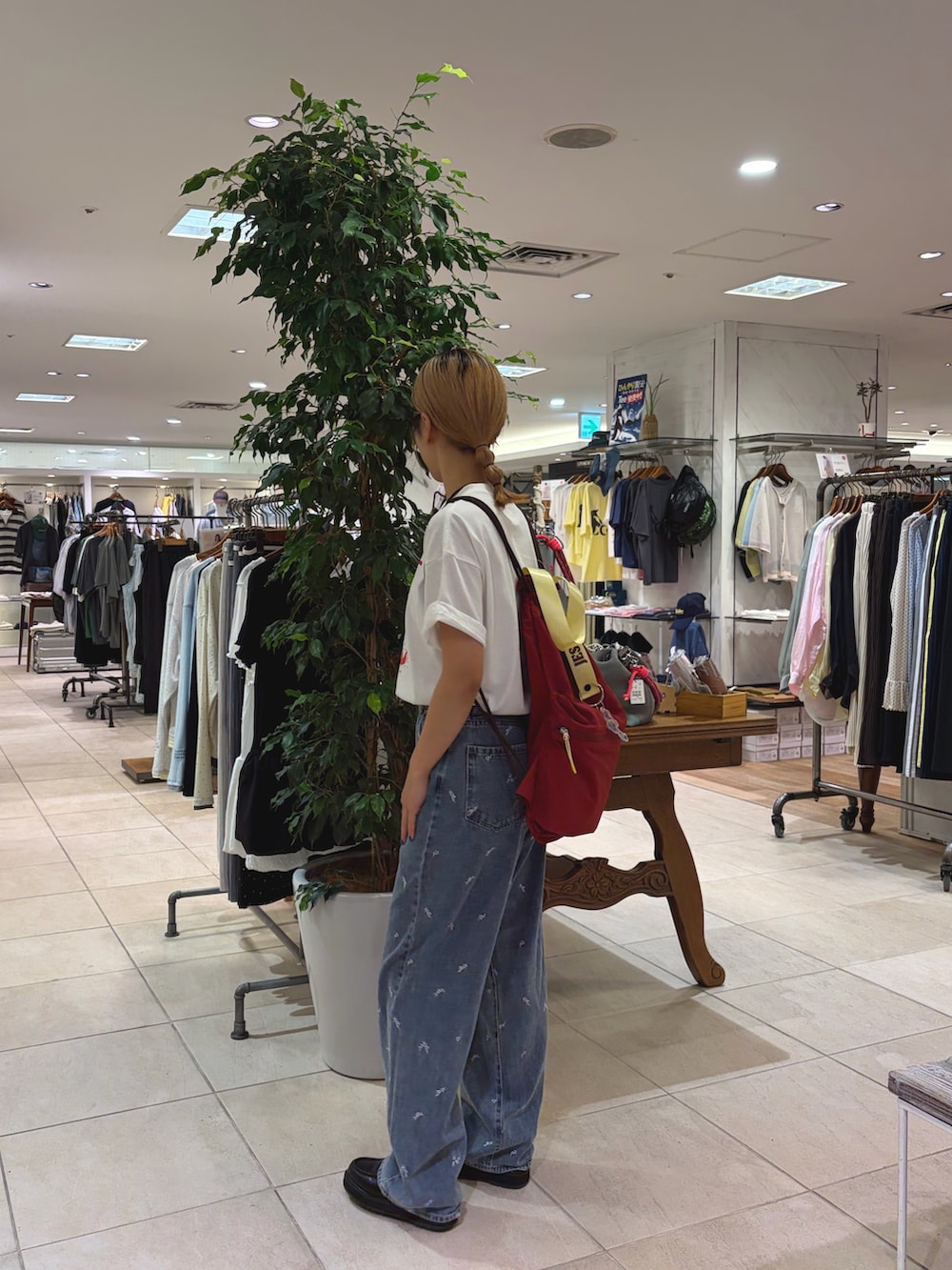 ホワイト系のTシャツ/カットソー、ブルー系のデニムパンツ、レッド系のバックパック/リュックを着用したレディースの夏コーディネートの2枚目の写真
