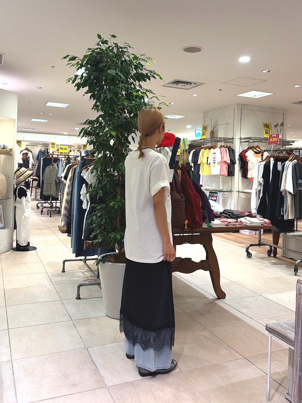 ホワイト系のTシャツ/カットソー、ブラック系のスカート、ブルー系のデニムパンツを着用したレディースの夏コーディネートの3枚目の写真