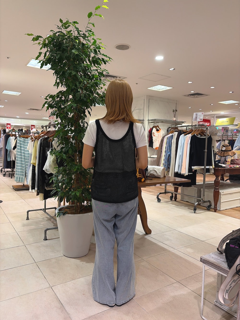 ブラック系のタンクトップ、ベージュ系のショルダーバッグ、ブルー系のデニムパンツを着用したレディースの夏コーディネートの2枚目の写真