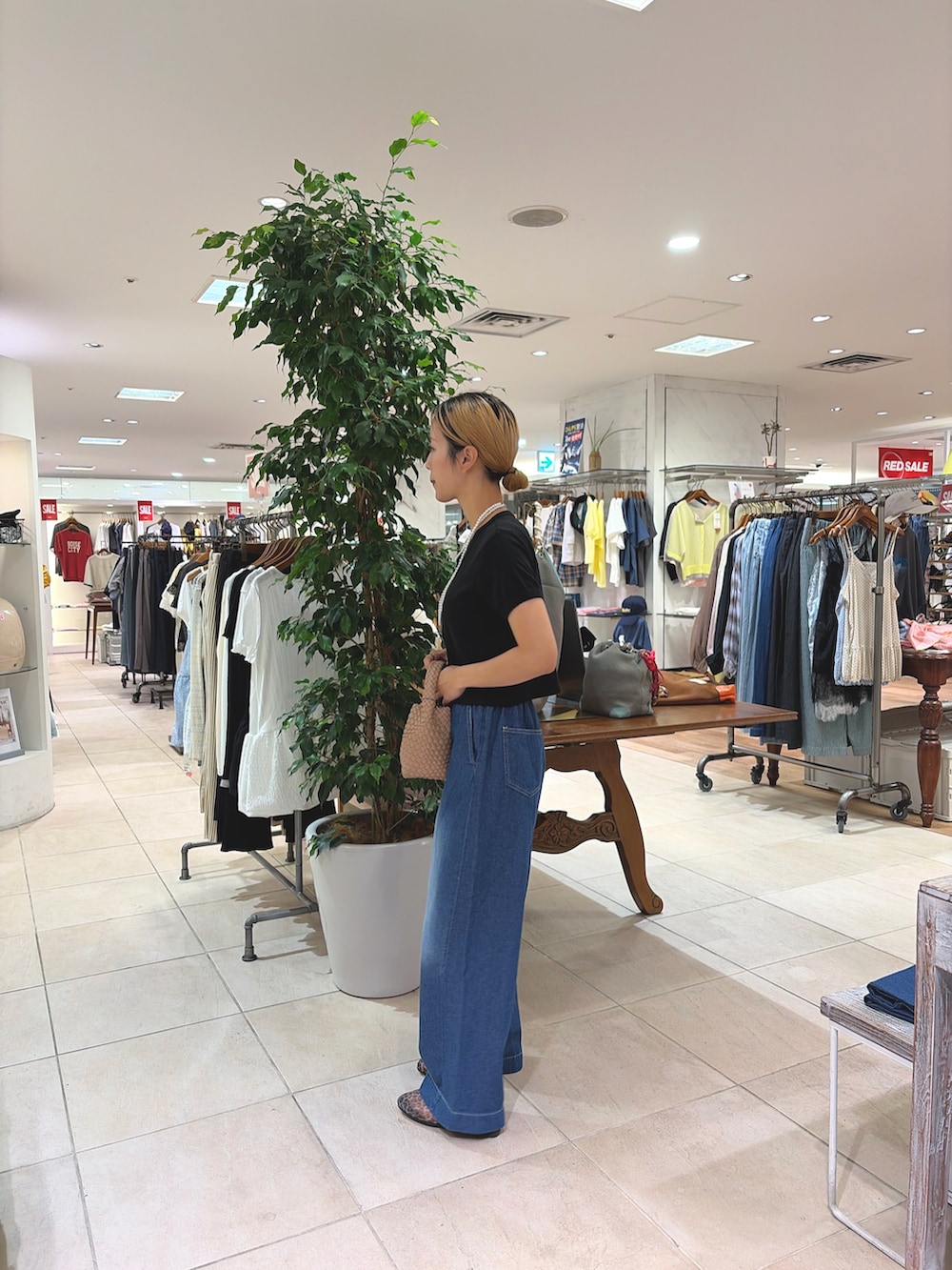 ブラック系のTシャツ/カットソー、ベージュ系のショルダーバッグ、ブルー系のデニムパンツを着用したレディースの夏コーディネートの3枚目の写真