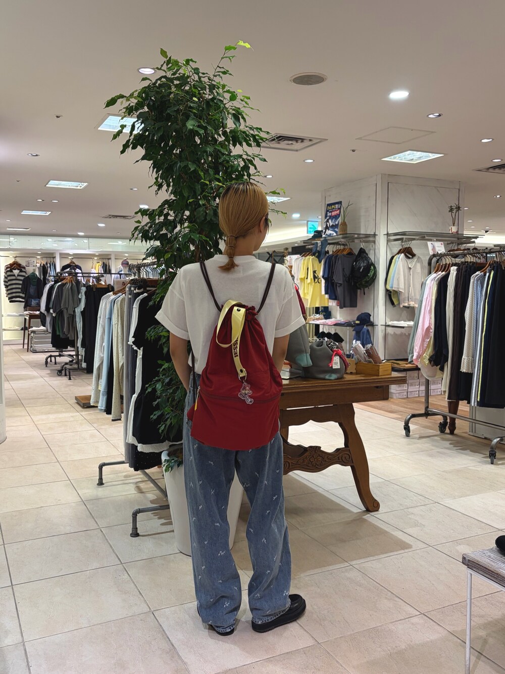 ホワイト系のTシャツ/カットソー、ブルー系のデニムパンツ、レッド系のバックパック/リュックを着用したレディースの夏コーディネートの3枚目の写真