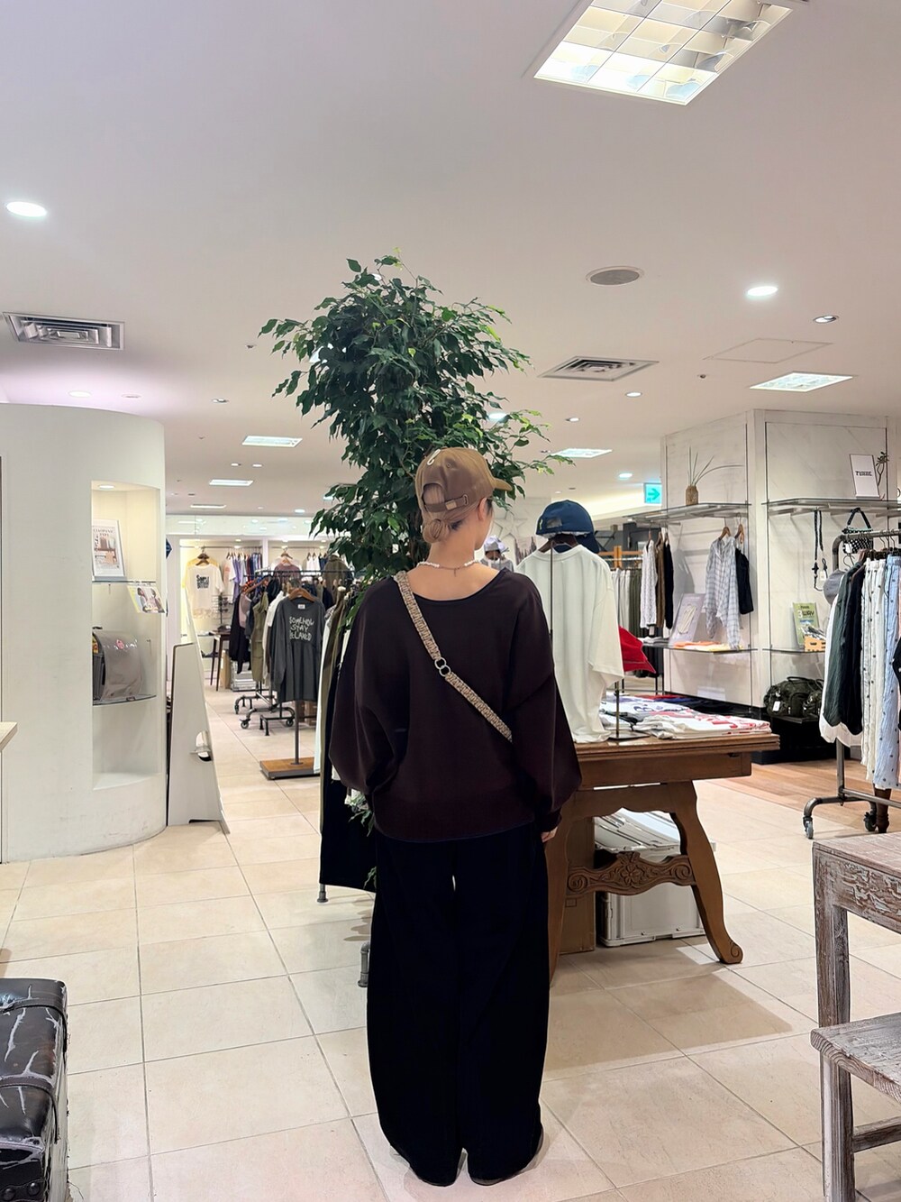 ブラック系のその他パンツ、イエロー系のキャップ、ベージュ系のスマホグッズを着用したレディースの秋コーディネートの2枚目の写真