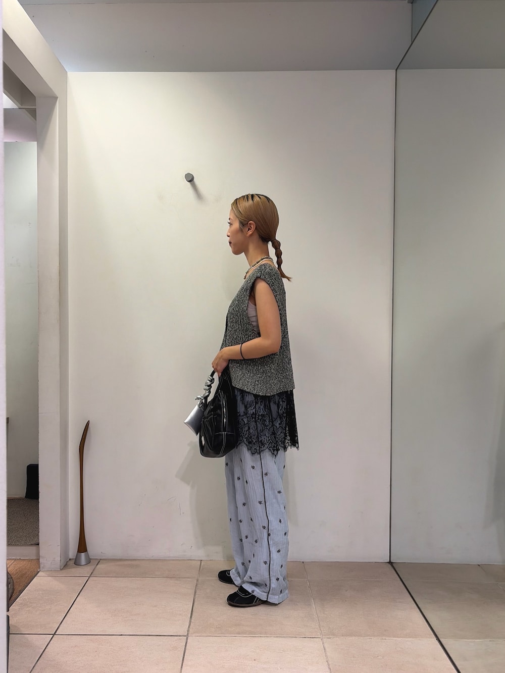 ブラック系のベスト、ブラック系のショルダーバッグ、ブルー系のその他パンツを着用したレディースの夏コーディネートの2枚目の写真