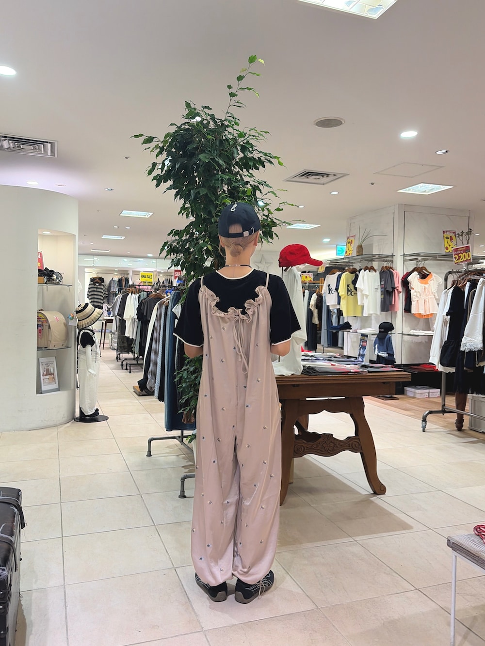 ベージュ系のサロペット/オーバーオール、ブラック系のニット/セーター、ブラック系のキャップを着用したレディースの夏コーディネートの2枚目の写真