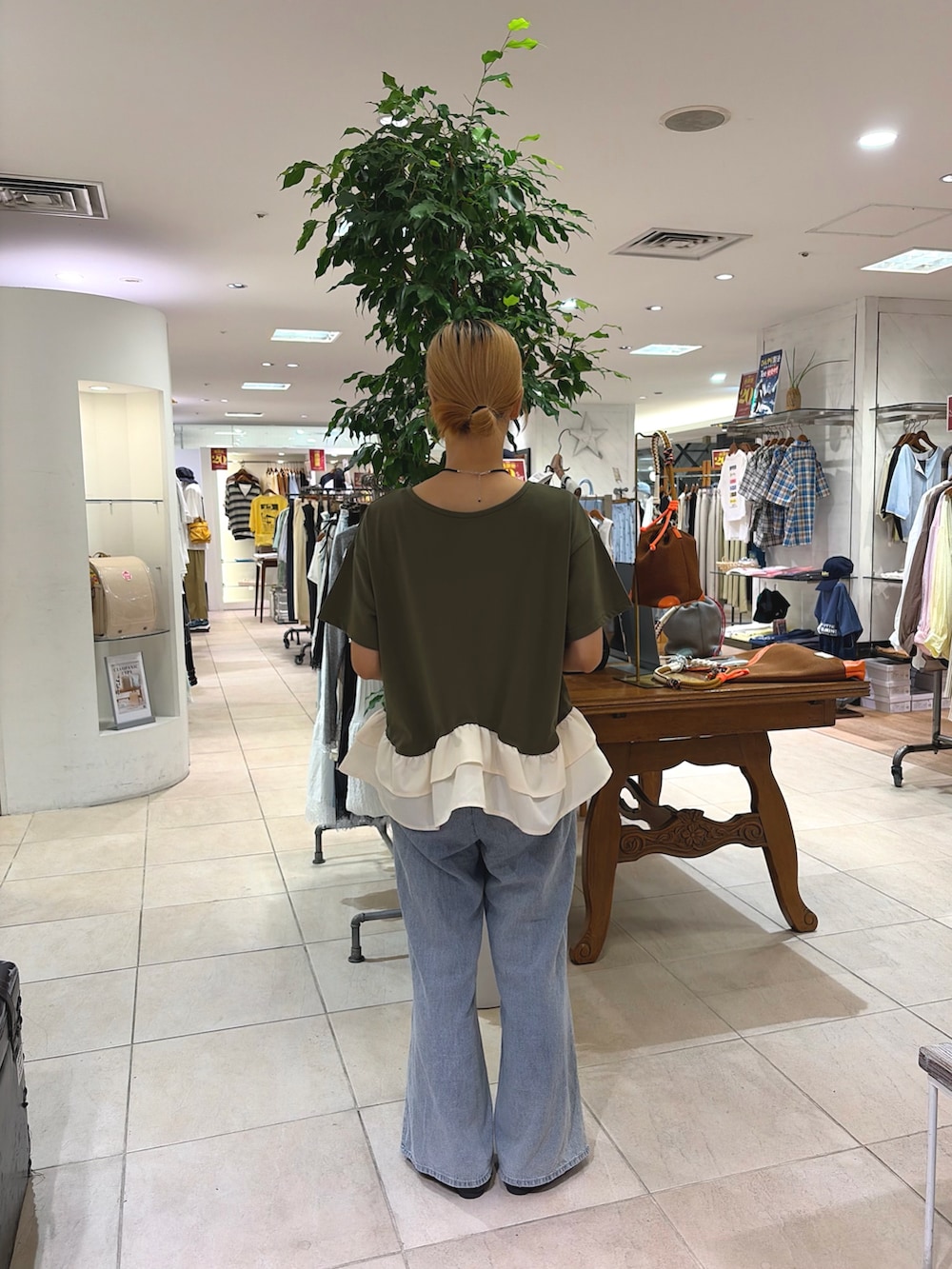 グリーン系のTシャツ/カットソー、ブルー系のデニムパンツ、ブラック系のパンプスを着用したレディースの夏コーディネートの2枚目の写真
