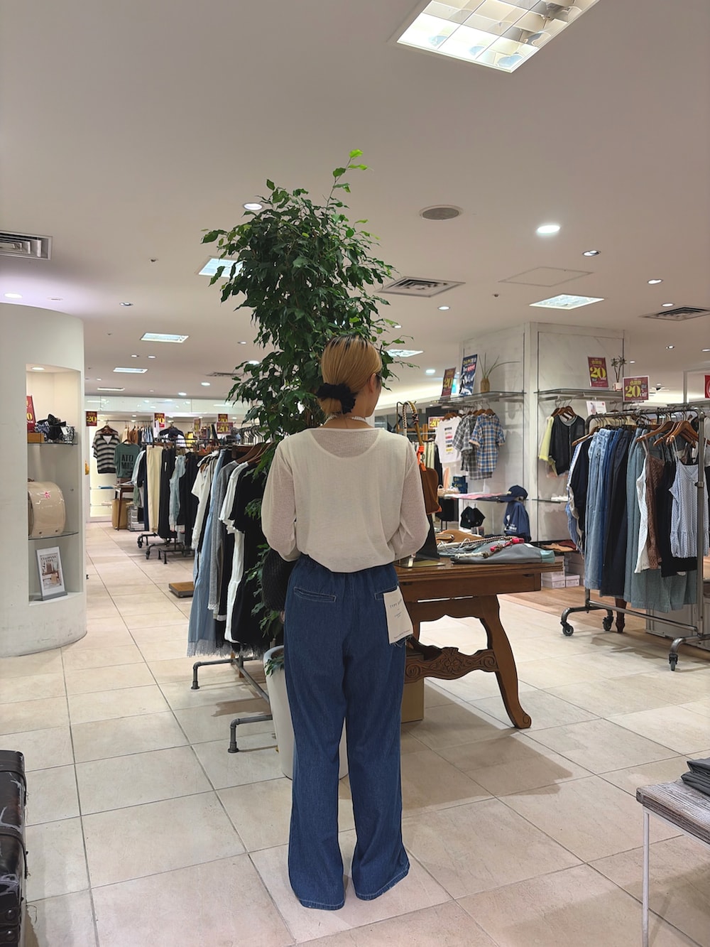 ホワイト系のカーディガン/ボレロ、ブラック系のショルダーバッグ、ブルー系のデニムパンツを着用したレディースの夏コーディネートの2枚目の写真