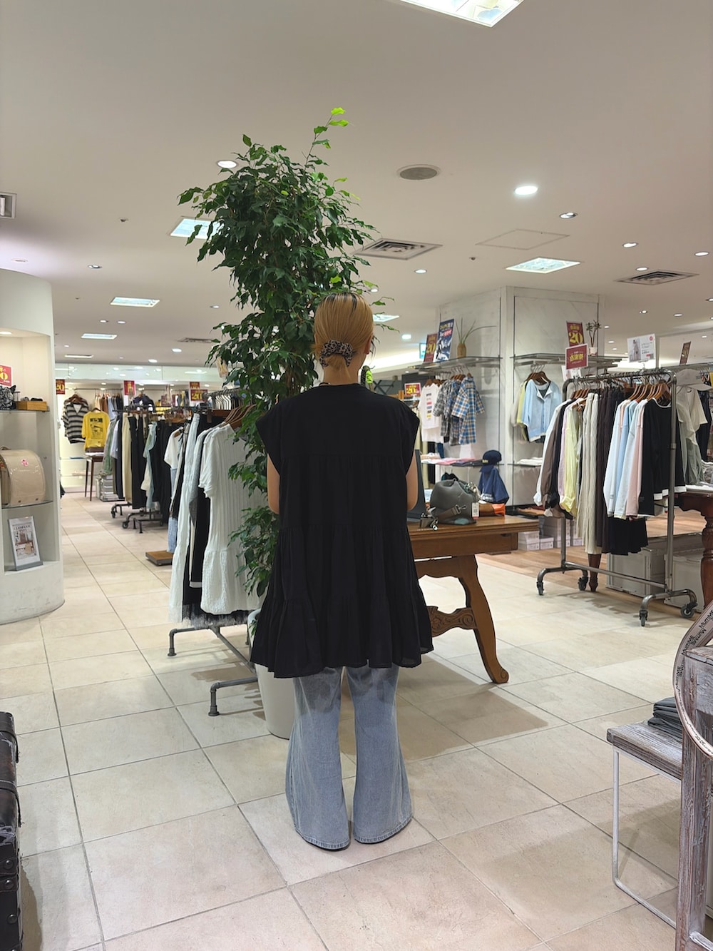 ブラック系のシャツ/ブラウス、グレー系のショルダーバッグ、ブルー系のデニムパンツを着用したレディースの夏コーディネートの2枚目の写真