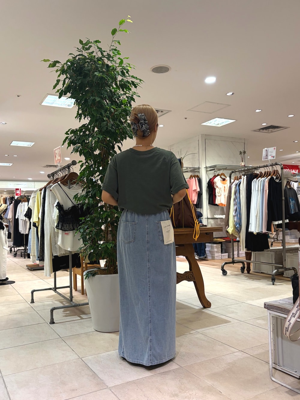 グリーン系のTシャツ/カットソー、ブルー系のスカート、ブラック系のローファーを着用したレディースの夏コーディネートの3枚目の写真