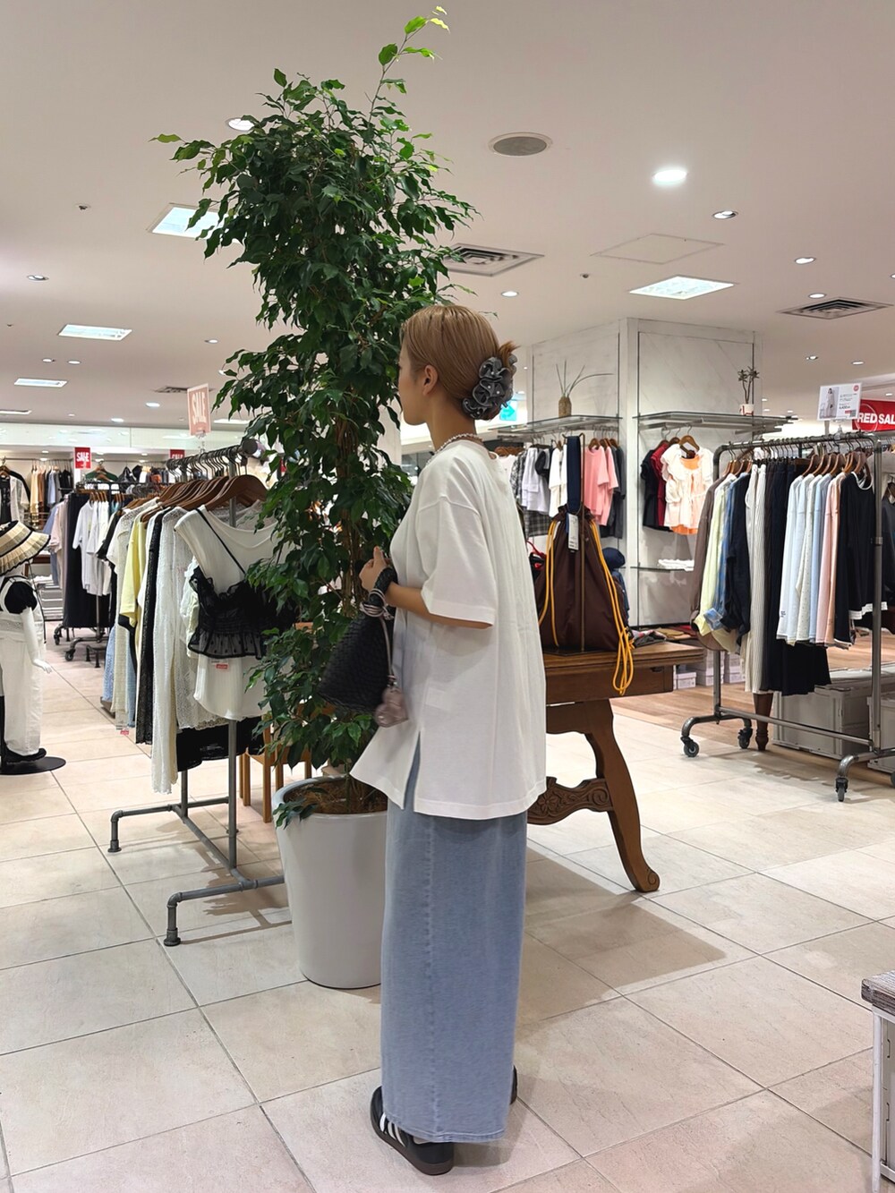 ホワイト系のTシャツ/カットソー、ブラック系のショルダーバッグ、ブルー系のスカートを着用したレディースの夏コーディネートの3枚目の写真