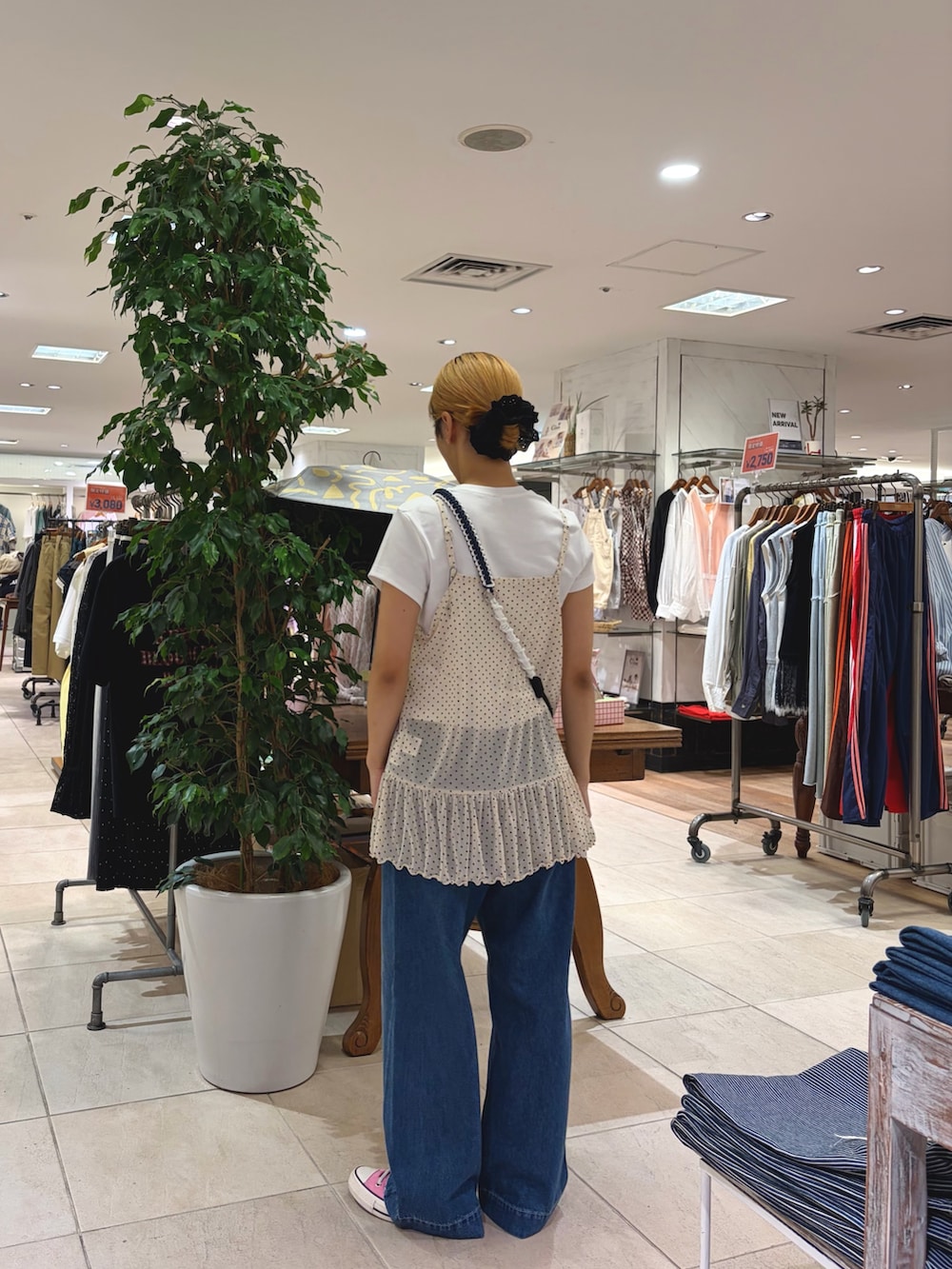ホワイト系のタンクトップ、ブルー系のデニムパンツ、ブラック系のショルダーバッグを着用したレディースの春コーディネートの2枚目の写真