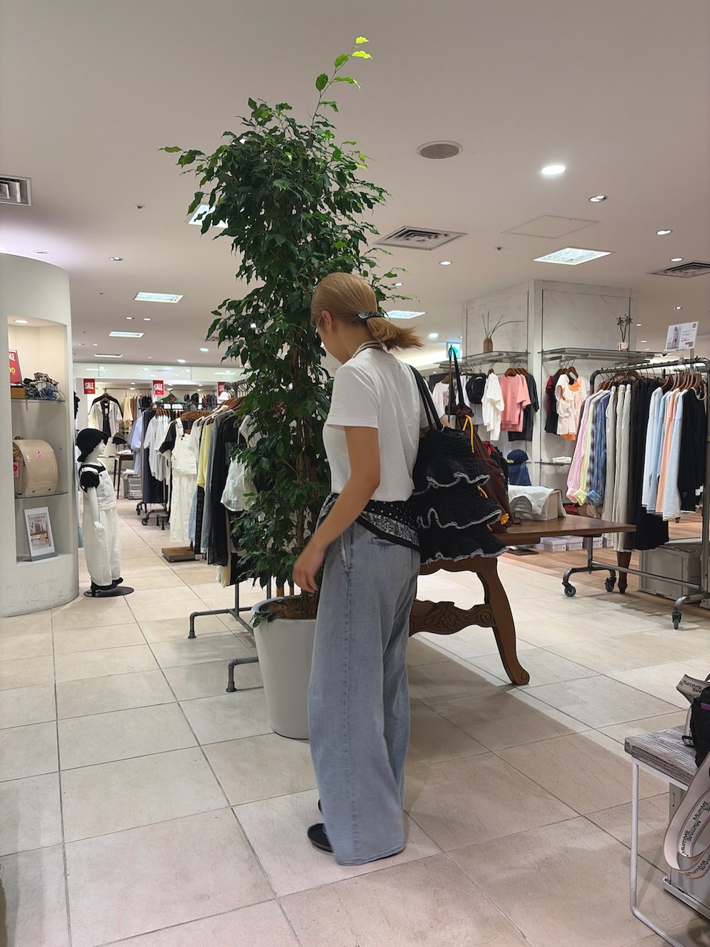 ブラック系のトートバッグ、ブルー系のデニムパンツ、ブラック系のバンダナ/スカーフを着用したレディースの夏コーディネートの3枚目の写真