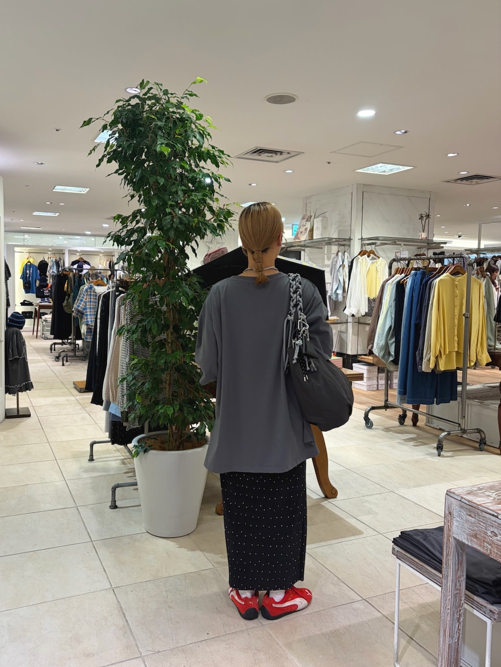 グレー系のTシャツ/カットソー、グレー系のトートバッグ、ブラック系のスカートを着用したレディースの春コーディネートの2枚目の写真