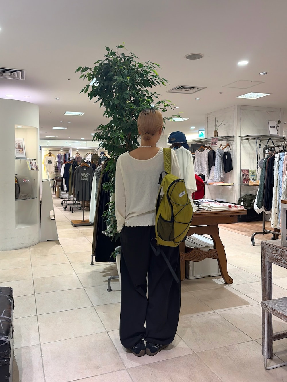 ホワイト系のTシャツ/カットソー、グリーン系のバックパック/リュック、ブラック系のその他パンツを着用したレディースの秋コーディネートの4枚目の写真