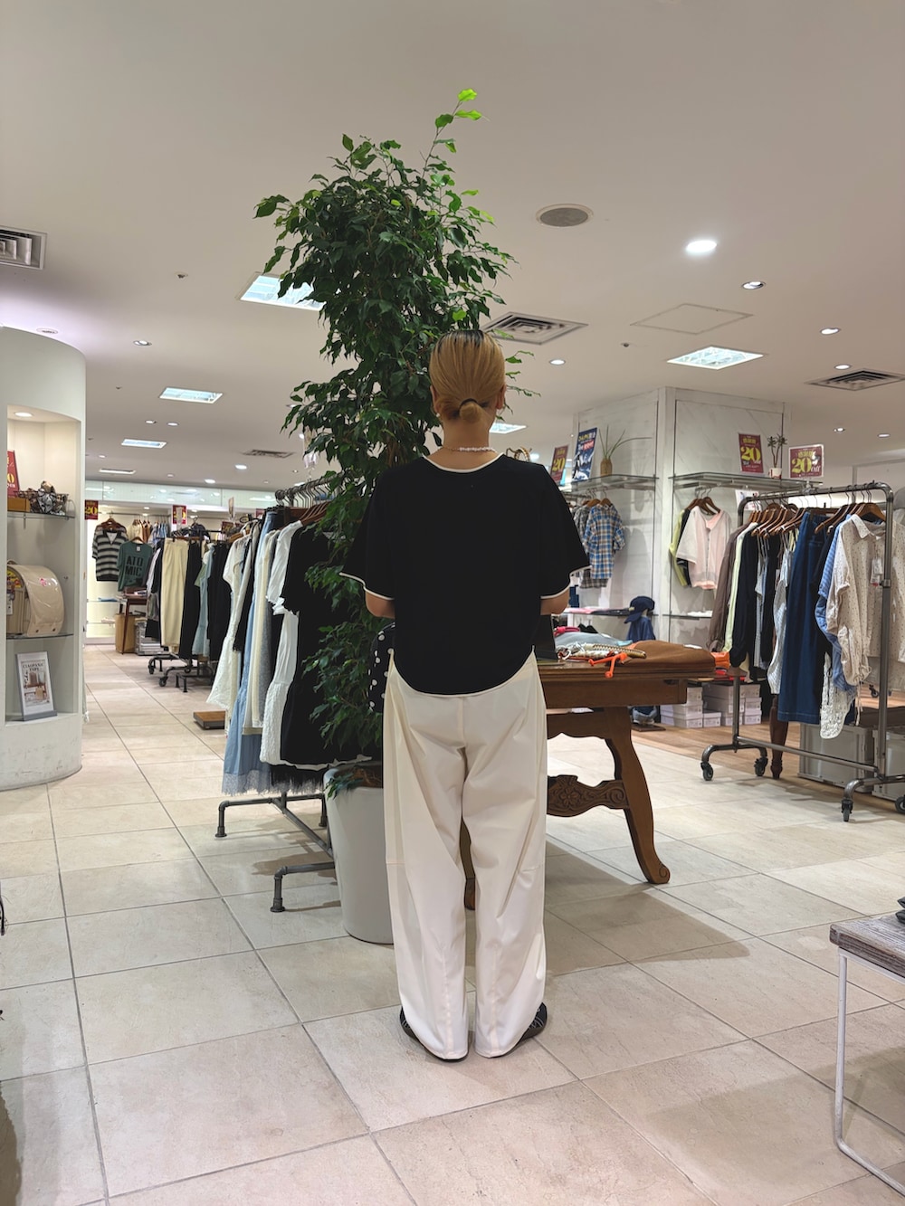 ブラック系のニット/セーター、ホワイト系のその他パンツ、ブラック系のボストンバッグを着用したレディースの夏コーディネートの2枚目の写真